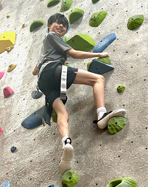 Congenital scoliosis patient, Kai Weir, climbing a rock wall.