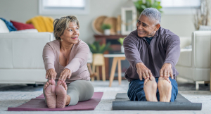 Senior couple exercising on yoga mats in home