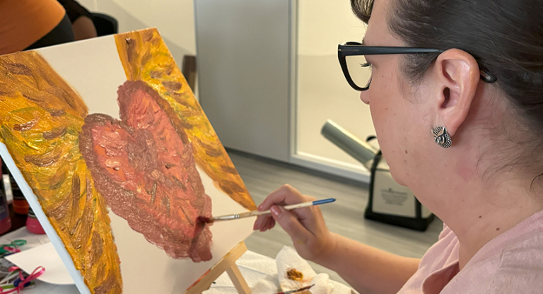 Melodie Smith, applying paintbrush strokes to a canvas