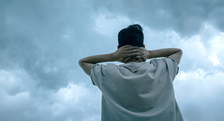 Man looking up storm clouds