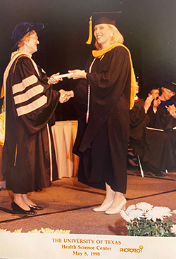 Kathy Hinze receiving diploma at graduation in 1998