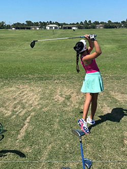 Ariella practicing her swing at the golf course