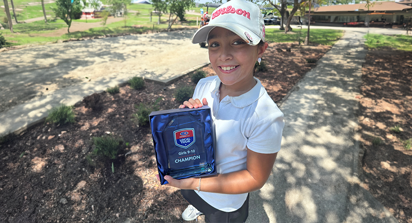 Ariella Konwar posing with her golf championship trophy.