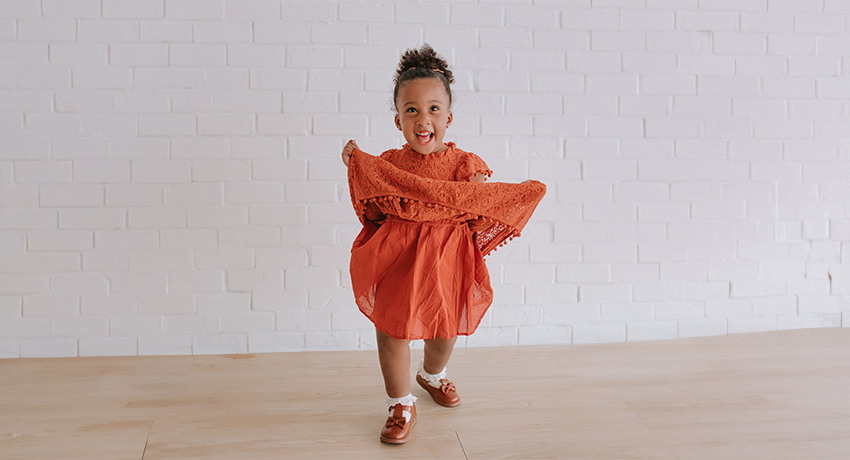 Luna Grayson poses in an orange dress