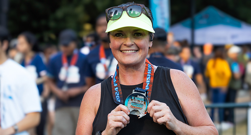 female holding race medal