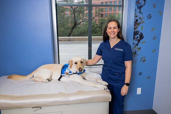 Rachel poses with Boris the dog in a clinic exam room